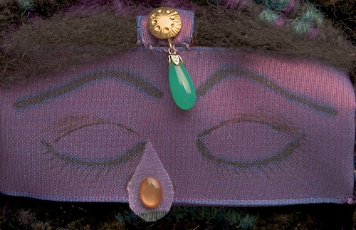 Penelope's tear, rose quartz, her face represented by a ribbon with closed eyes drawn on it, and above an ornament matching a similar ornament, midline on her sister's brow.